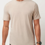 Man wearing a beige t-shirt against a plain background