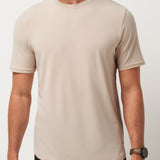Man wearing a beige t-shirt against a plain background