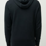 Man wearing a black hoodie from behind on a light gray background