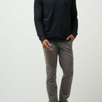 Man wearing a black hoodie and gray pants on a white background
