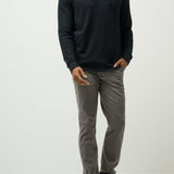Man wearing a black hoodie and gray pants on a white background