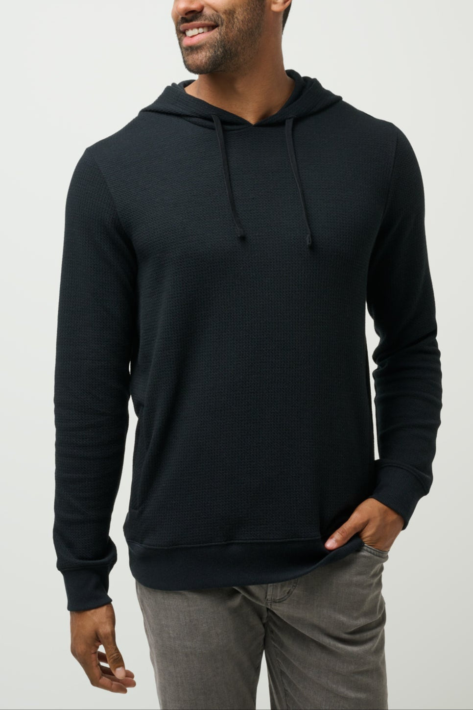 Man wearing a black hoodie on a light gray background