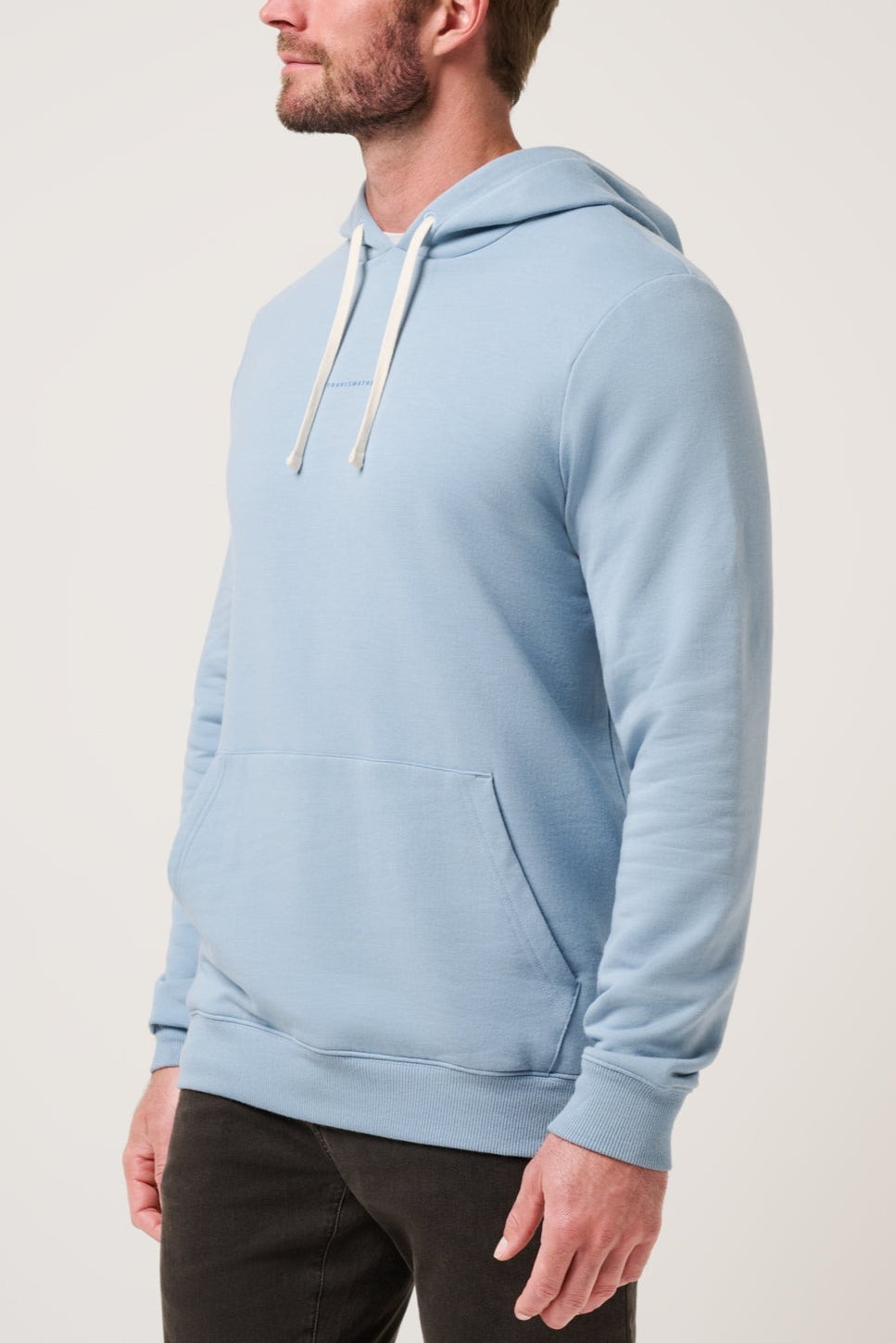 Man wearing a light blue hoodie on a plain background