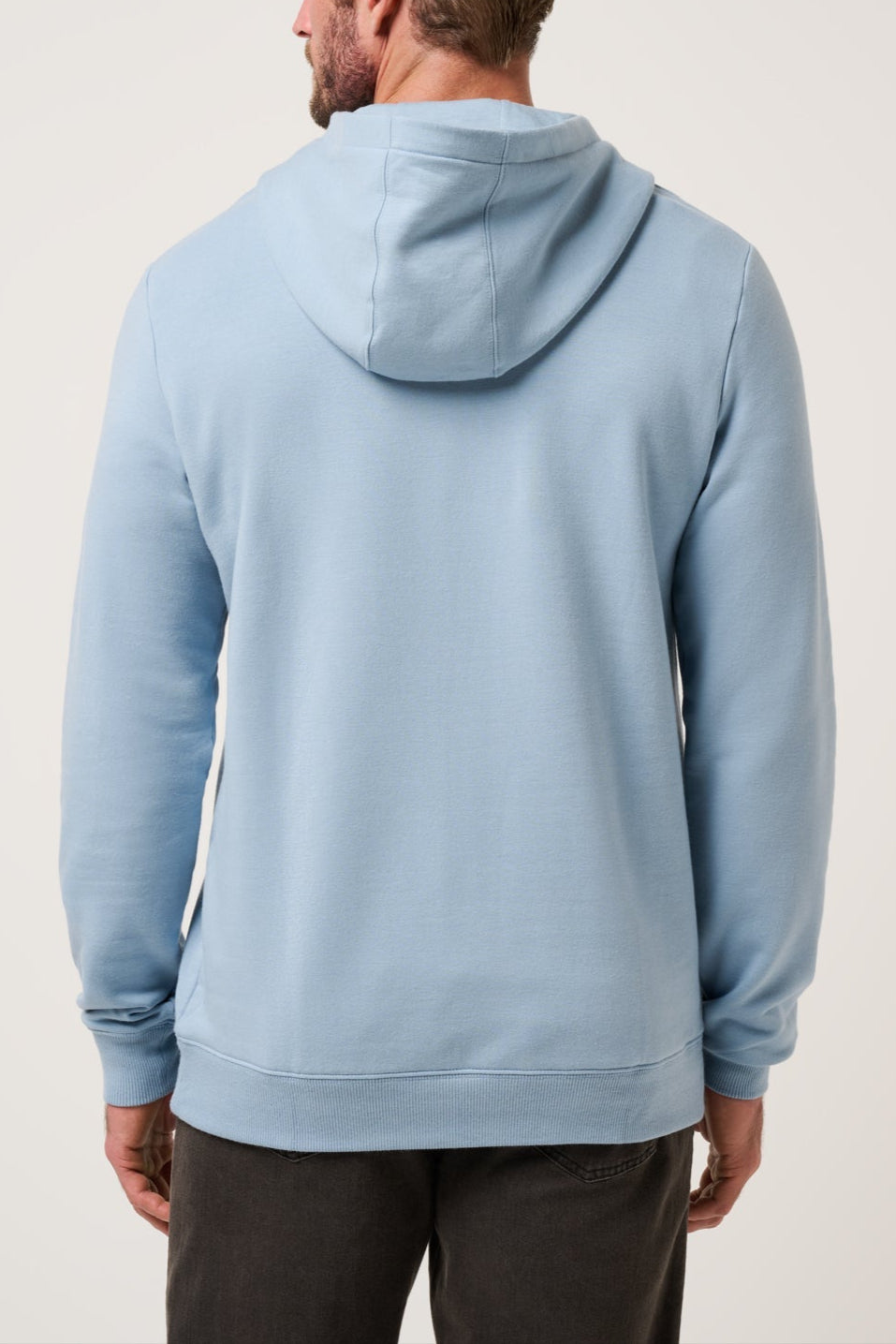 Man wearing a light blue hoodie from behind on a plain background