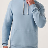 Man wearing a light blue hoodie against a plain background