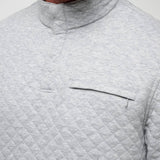 Close-up of a gray quilted jacket with a pocket on a light gray background
