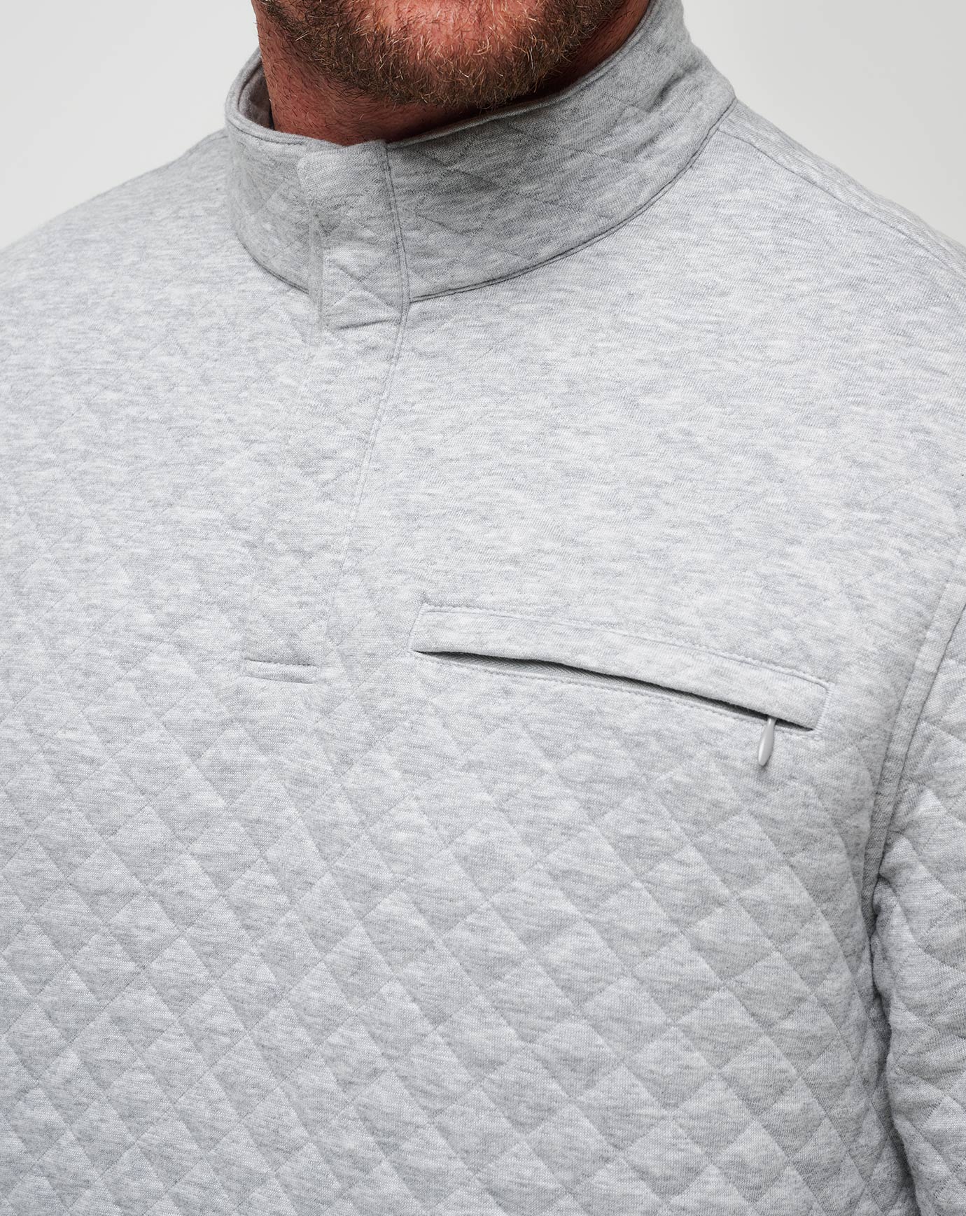 Close-up of a gray quilted jacket with a pocket on a light gray background