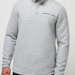 Man wearing a gray quilted pullover against a light gray background