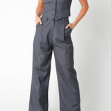Woman wearing a gray jumpsuit with a vest on a white background