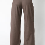 Brown pants worn with a suit jacket on a white background