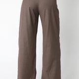 Brown pants worn with a suit jacket on a white background