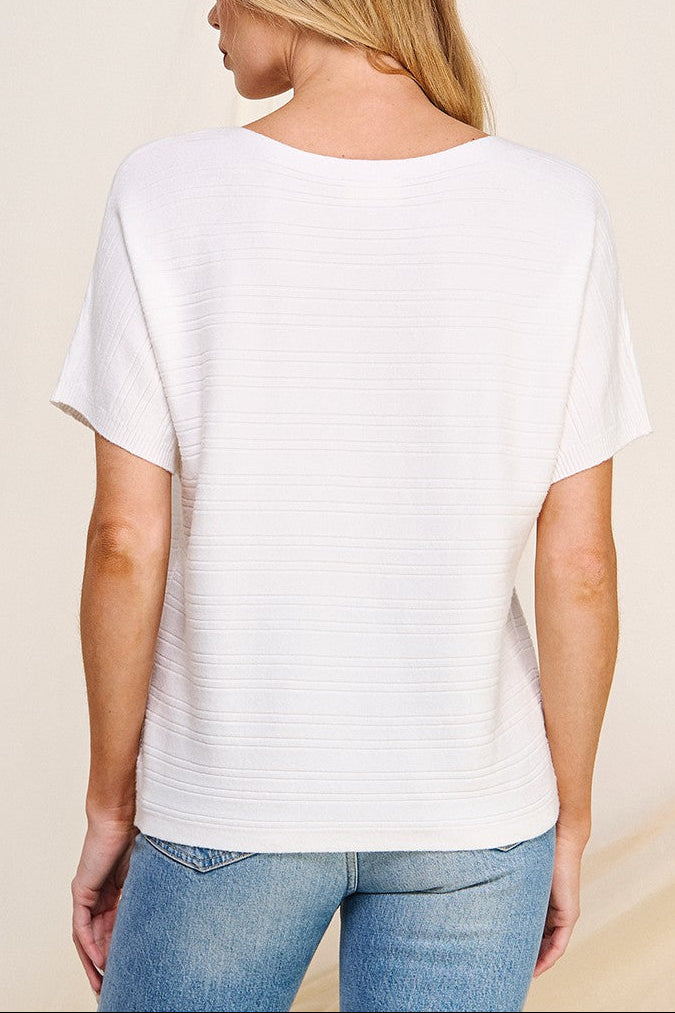 Person wearing a white t-shirt and blue jeans on a beige background