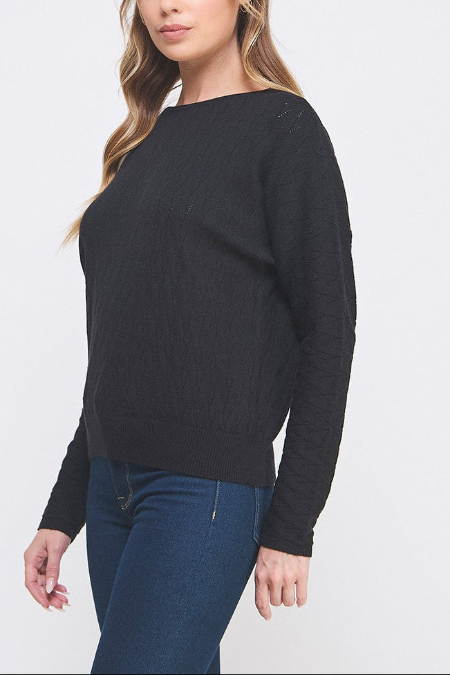 Woman wearing a black sweater and blue pants on a white background