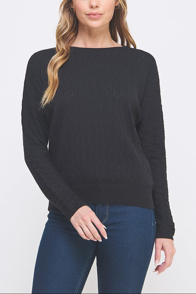 Woman wearing a black sweater and blue jeans on a white background