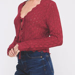 Woman wearing a red knitted top and blue jeans on a white background