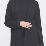 Woman wearing a black blazer over a black top on a white background