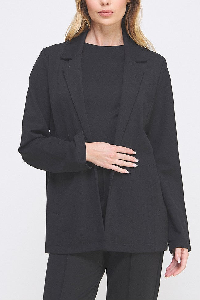 Woman wearing a black blazer over a black top on a white background