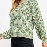 Woman wearing a green patterned sweater on a white background