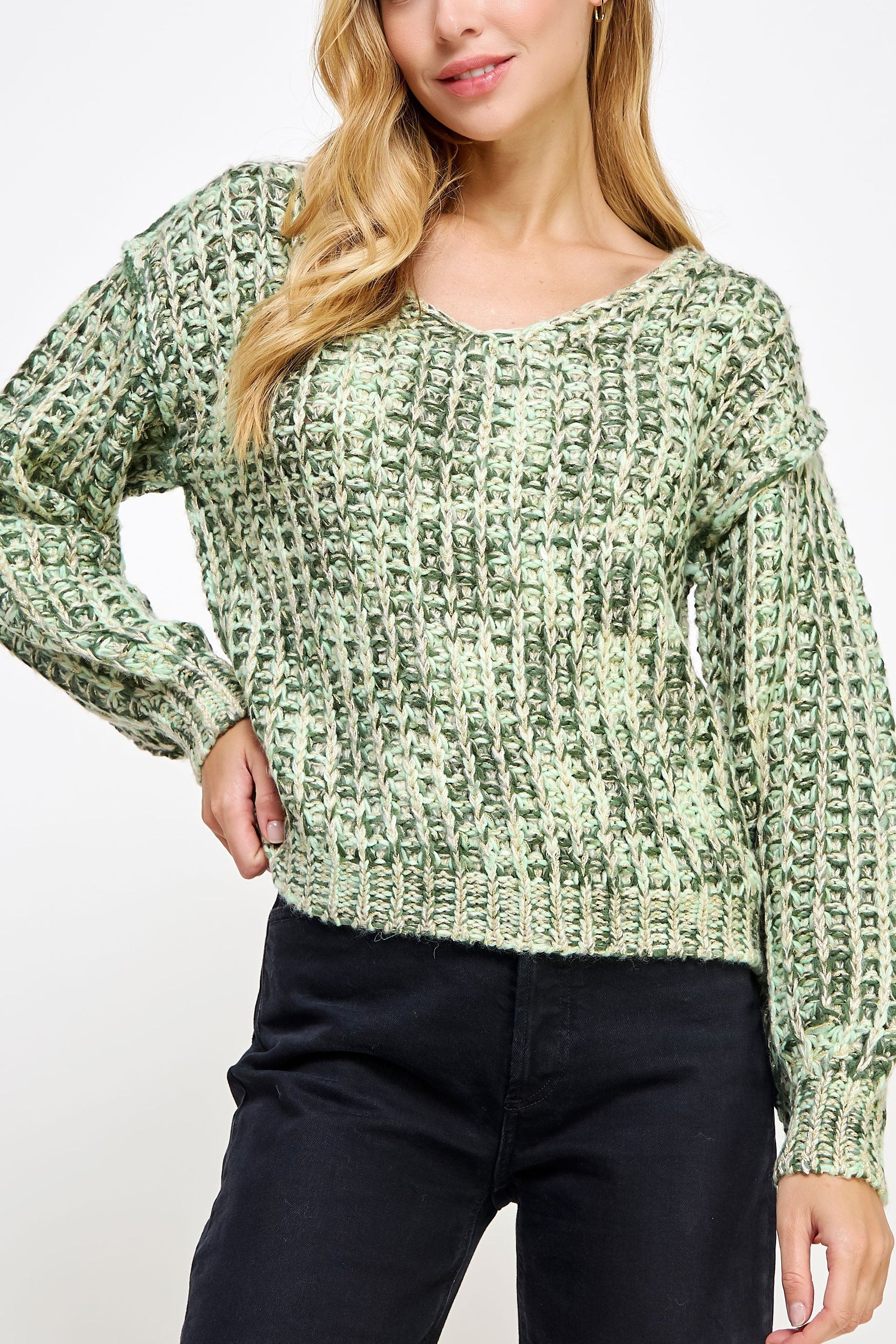 Woman wearing a green patterned sweater on a white background