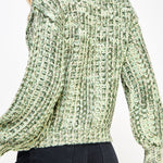 Woman wearing a green textured sweater on a white background