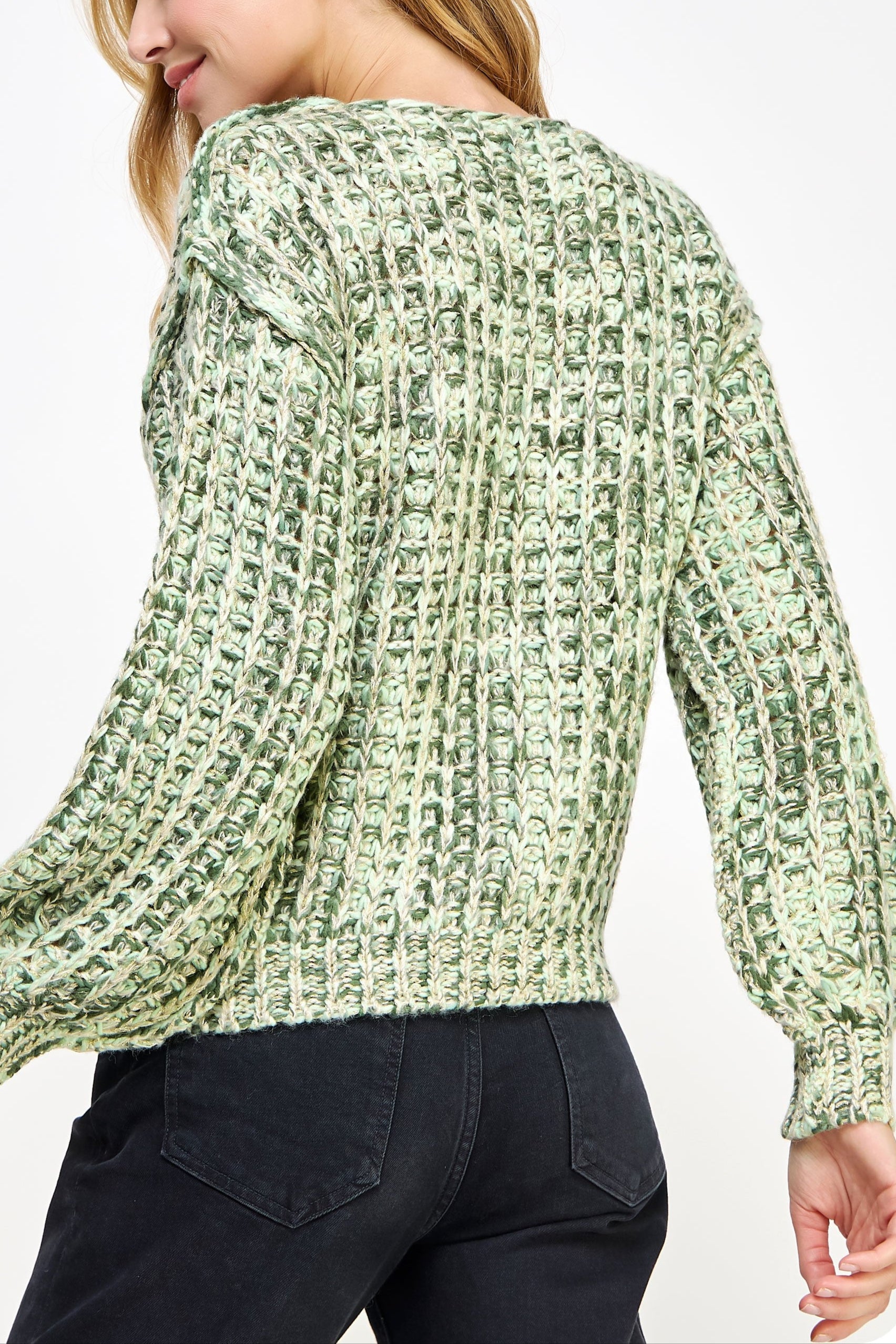 Woman wearing a green textured sweater on a white background