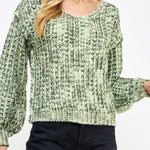 Woman wearing a green patterned sweater against a white background