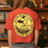 Woman wearing red Duvin Beach Club cropped t-shirt with circular logo featuring surfer design