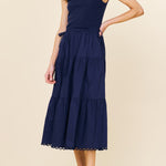 Woman wearing a navy blue dress on a beige background