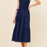 Woman wearing a navy blue dress on a beige background