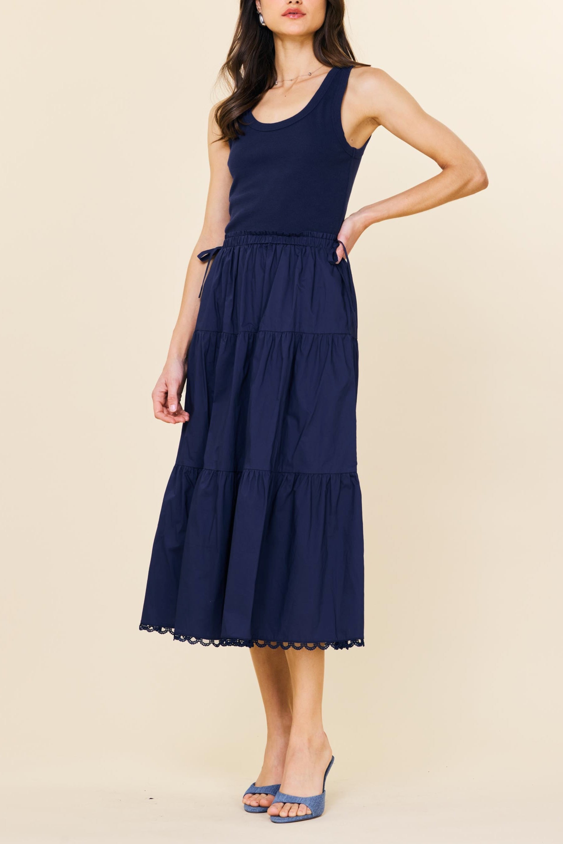 Woman wearing a navy blue dress on a beige background