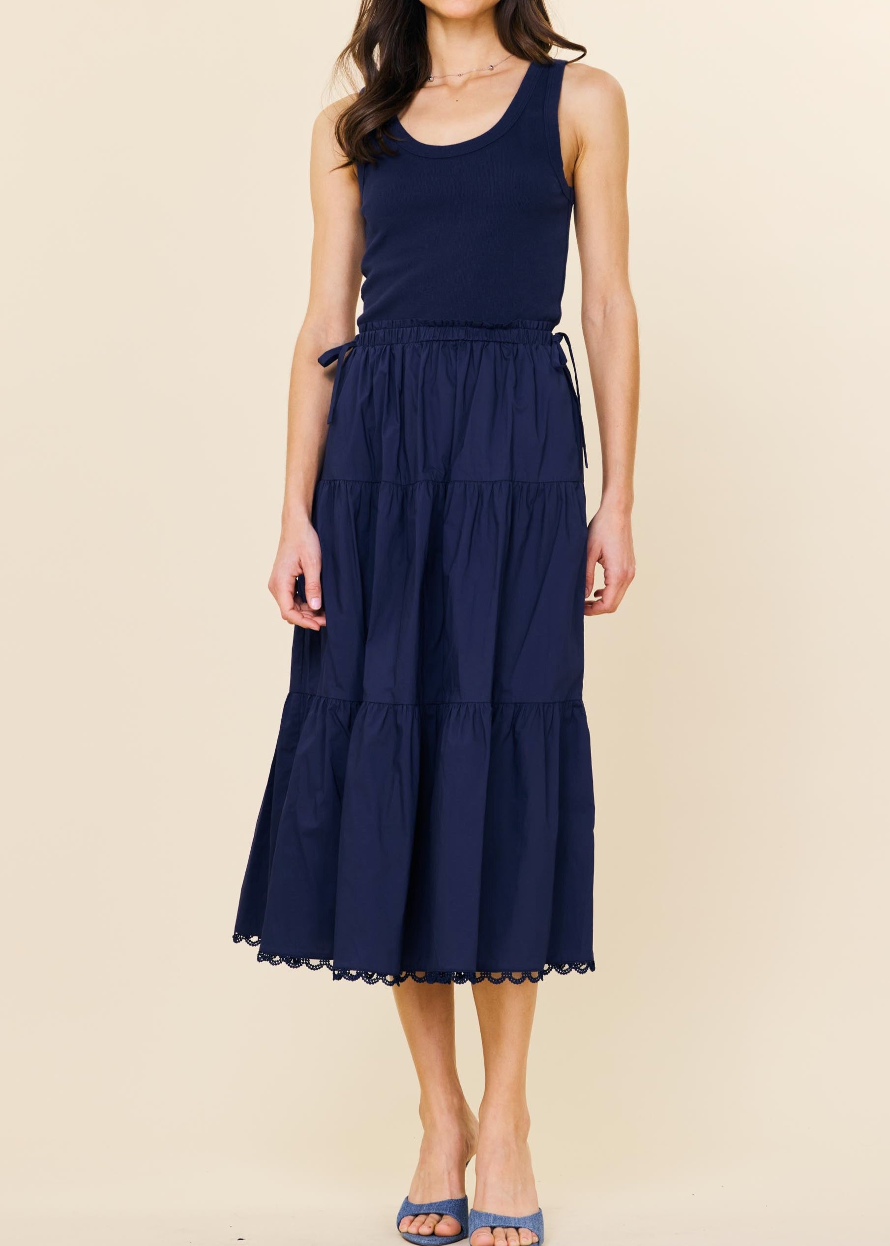 Woman wearing a navy blue dress on a beige background