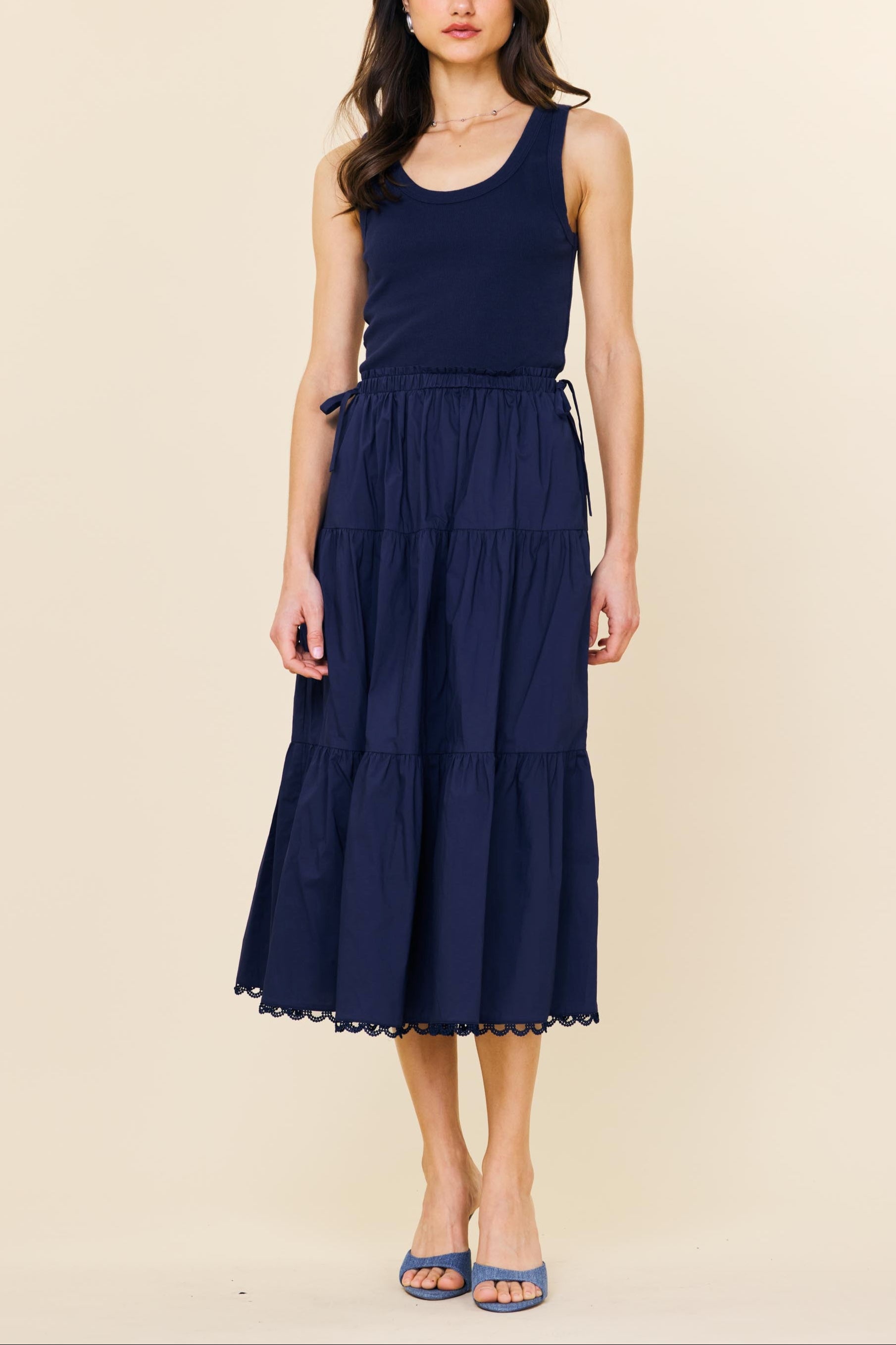 Woman wearing a navy blue dress on a beige background