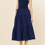 Woman wearing a navy blue dress on a beige background