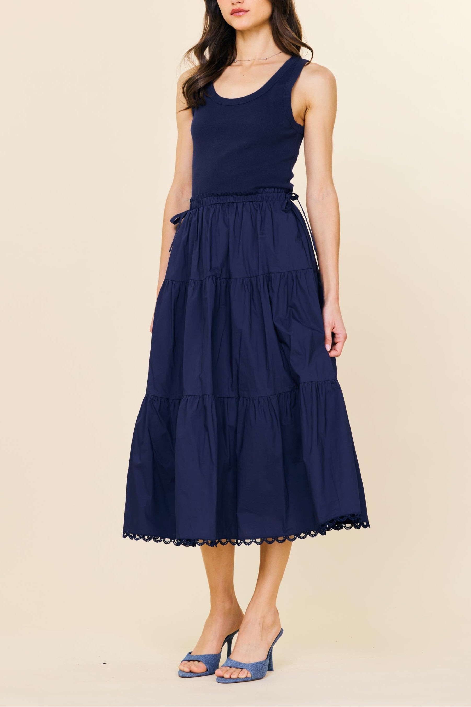 Woman wearing a navy blue dress on a beige background