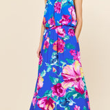 Woman wearing a colorful floral dress against a beige background