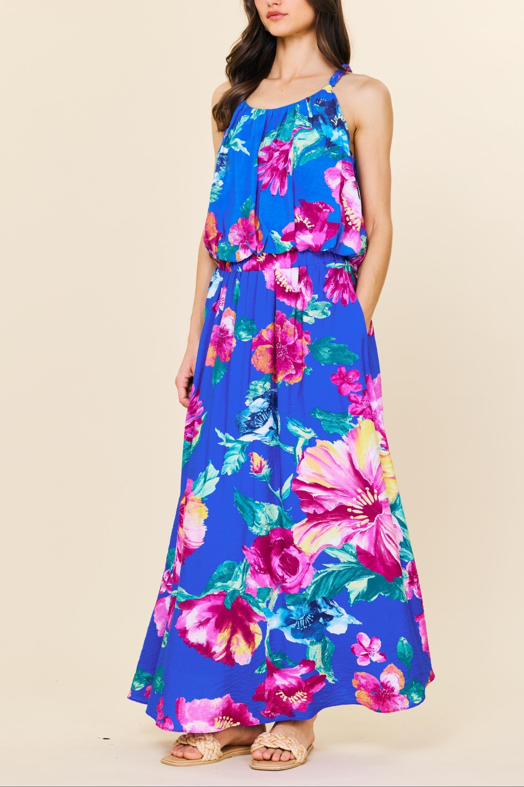 Woman wearing a colorful floral dress against a beige background