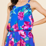 Woman wearing a blue floral dress against a beige background