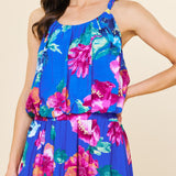 Woman wearing a blue floral dress against a beige background
