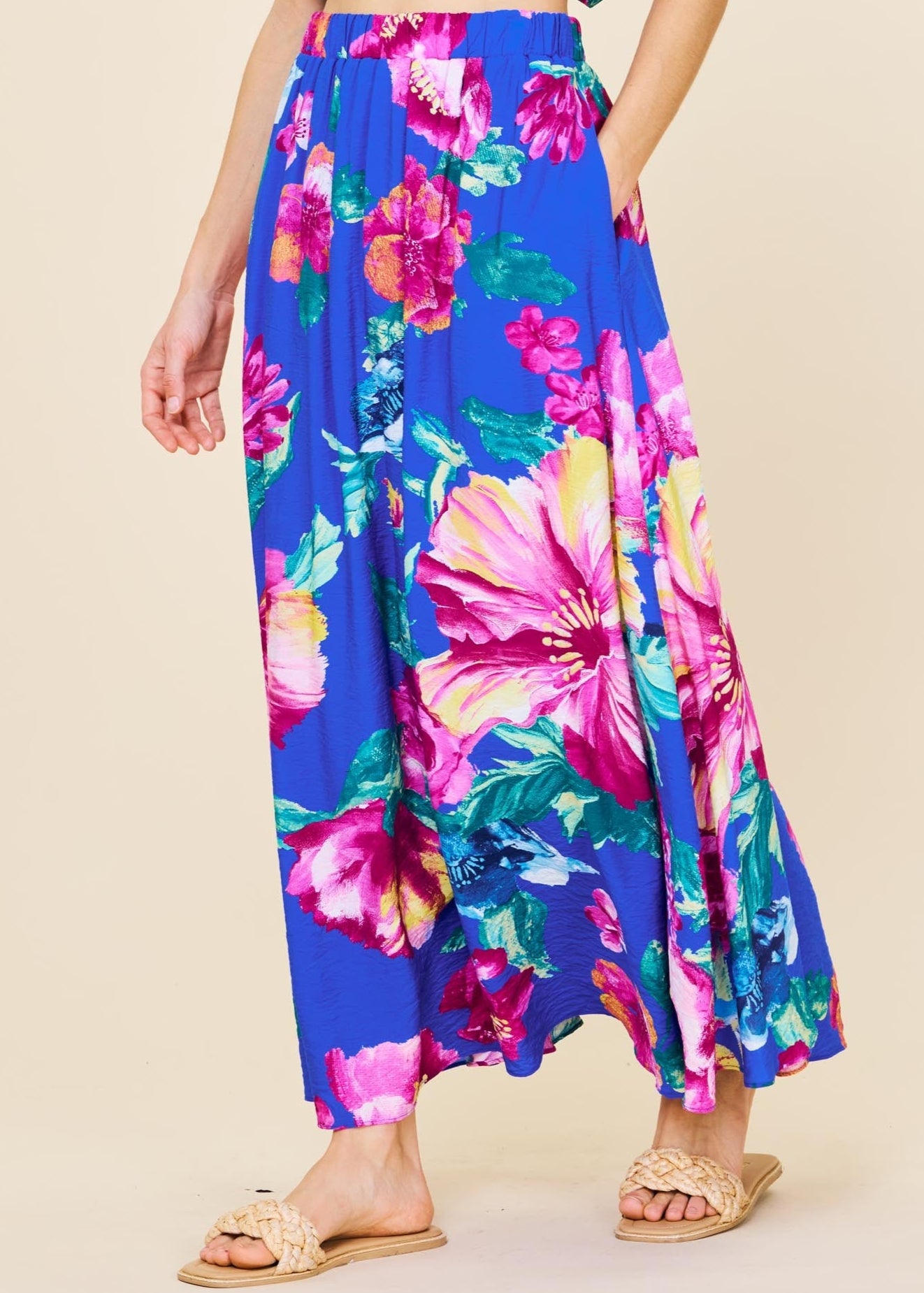 Woman wearing a colorful floral outfit on a beige background