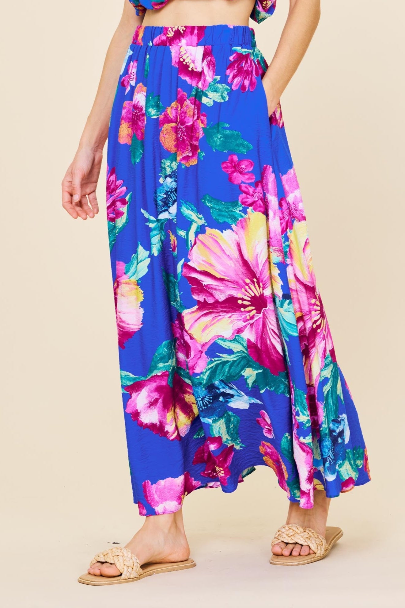 Woman wearing a colorful floral outfit on a beige background