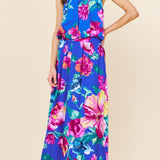 Woman wearing a colorful floral dress on a beige background