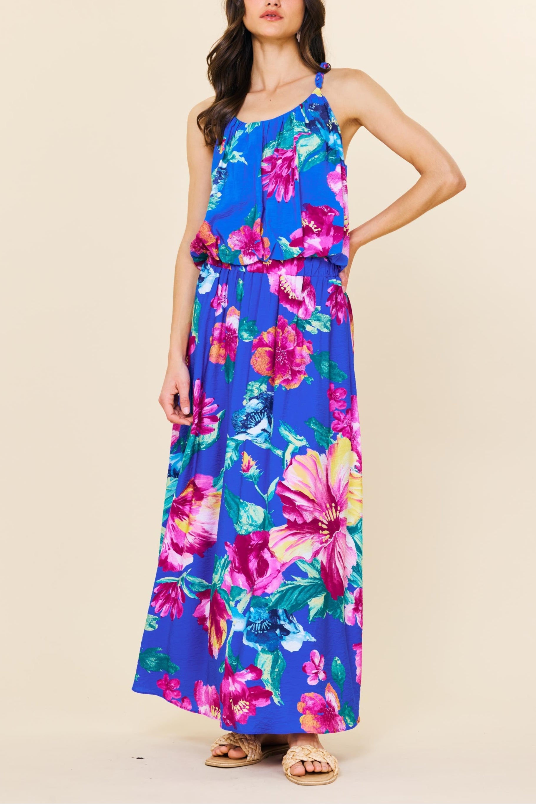 Woman wearing a colorful floral dress on a beige background