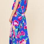Woman wearing a colorful floral dress on a beige background