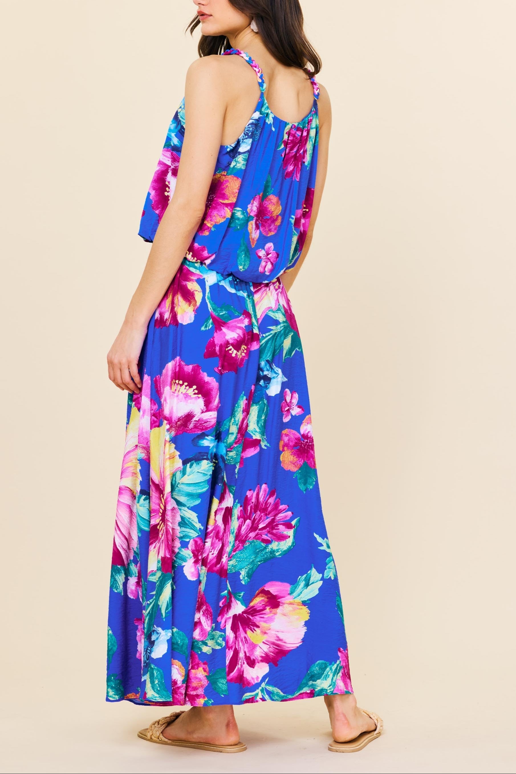 Woman wearing a colorful floral dress on a beige background