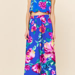 Woman wearing a colorful floral outfit on a beige background