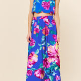 Woman wearing a colorful floral outfit on a beige background