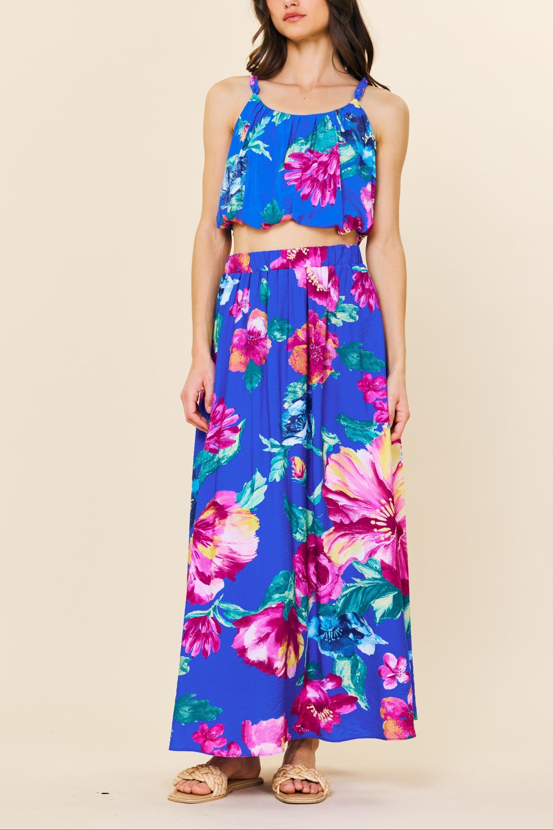 Woman wearing a colorful floral outfit on a beige background