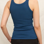 Person wearing a blue tank top against a plain background