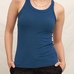 Woman wearing a blue tank top against a plain background