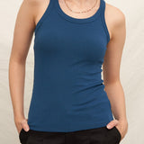 Woman wearing a blue tank top against a plain background